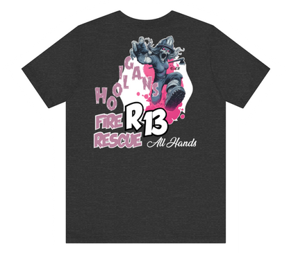 A dark heather gray t-shirt featuring a large graphic print on the front. The graphic depicts a firefighter in a dynamic pose with the text 'HOLICAN FIRE RESCUE', 'R13', and 'All Hands' in pink, white, and black.