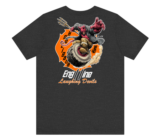 A dark heather gray t-shirt featuring a large graphic print on the front. The graphic depicts a devil-like character with a trident riding a tire, set against an orange circular background with the text 'H O C T O B 1988' and 'Engine Laughing Devils' written below.
